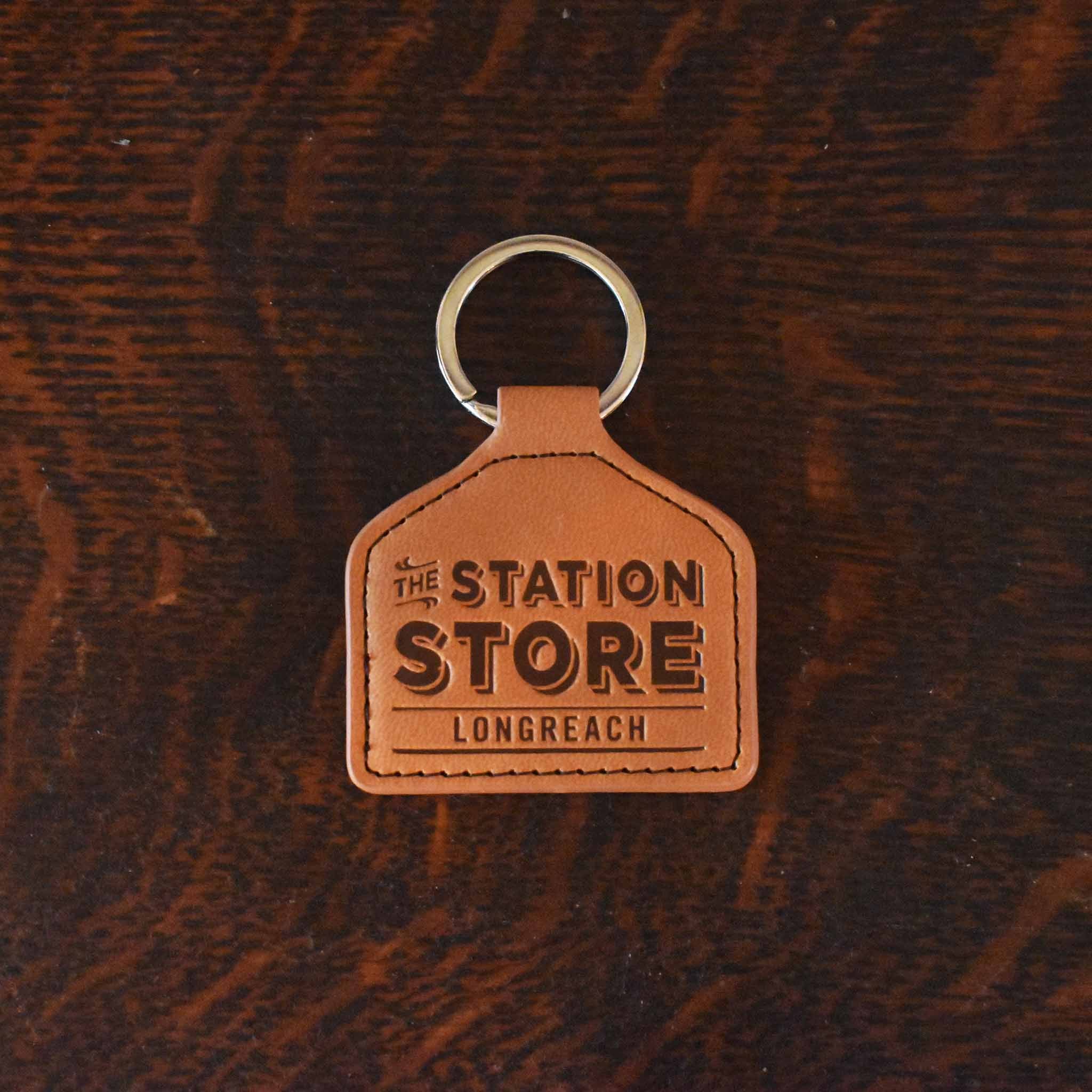 Leather keyring shaped like a cattle tag with The Station Store Longreach debossed. n