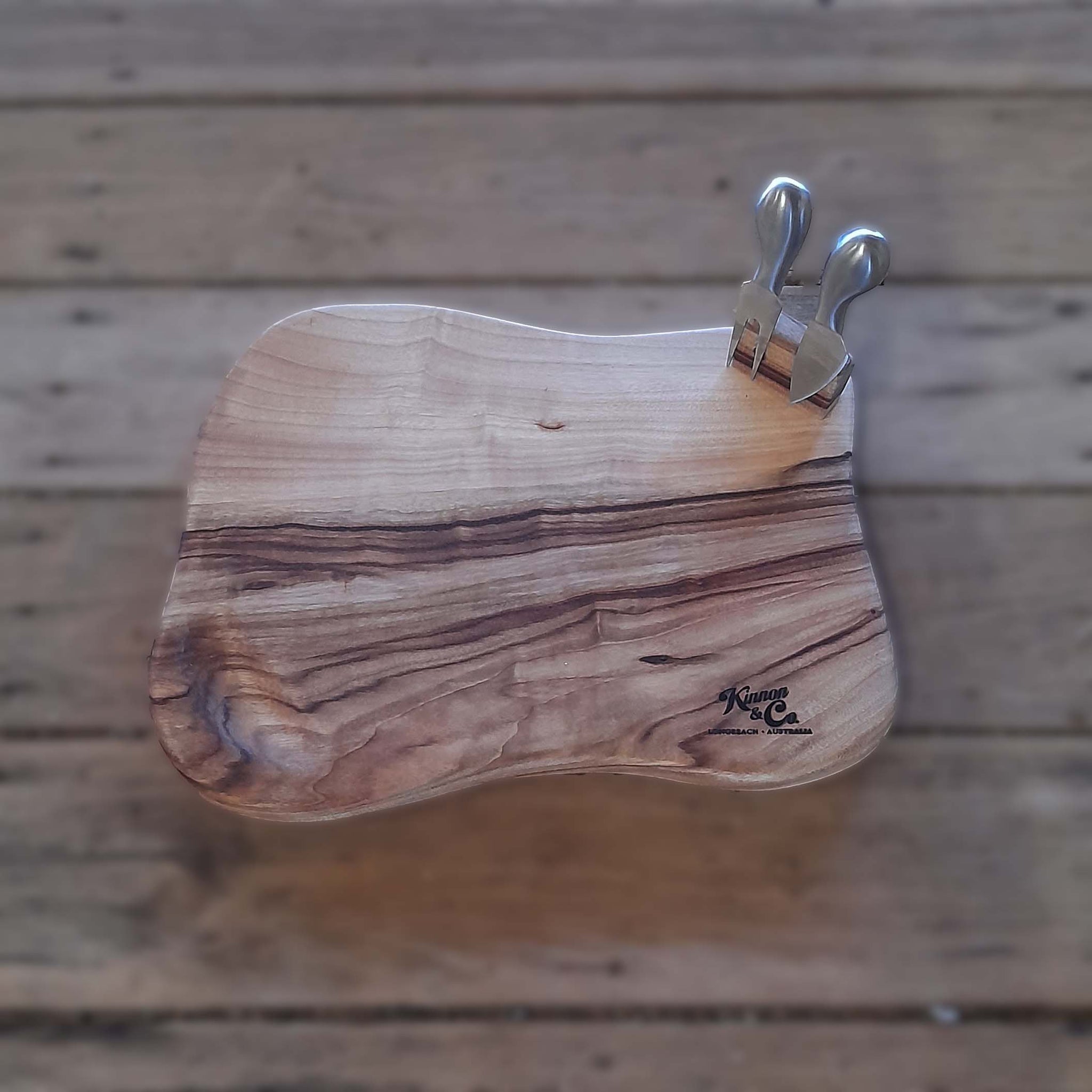 Kinnon and Co branded Camphor Laurel Cheeseboard Freeforrm with two stainless steel tools.