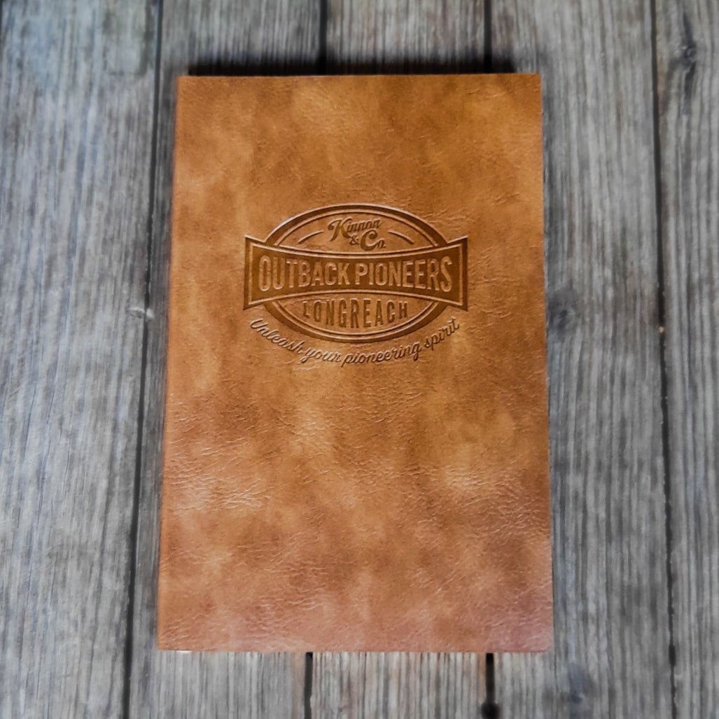 Soft Cover Notebook Brown with debossed Outback Pioneers logo on front.