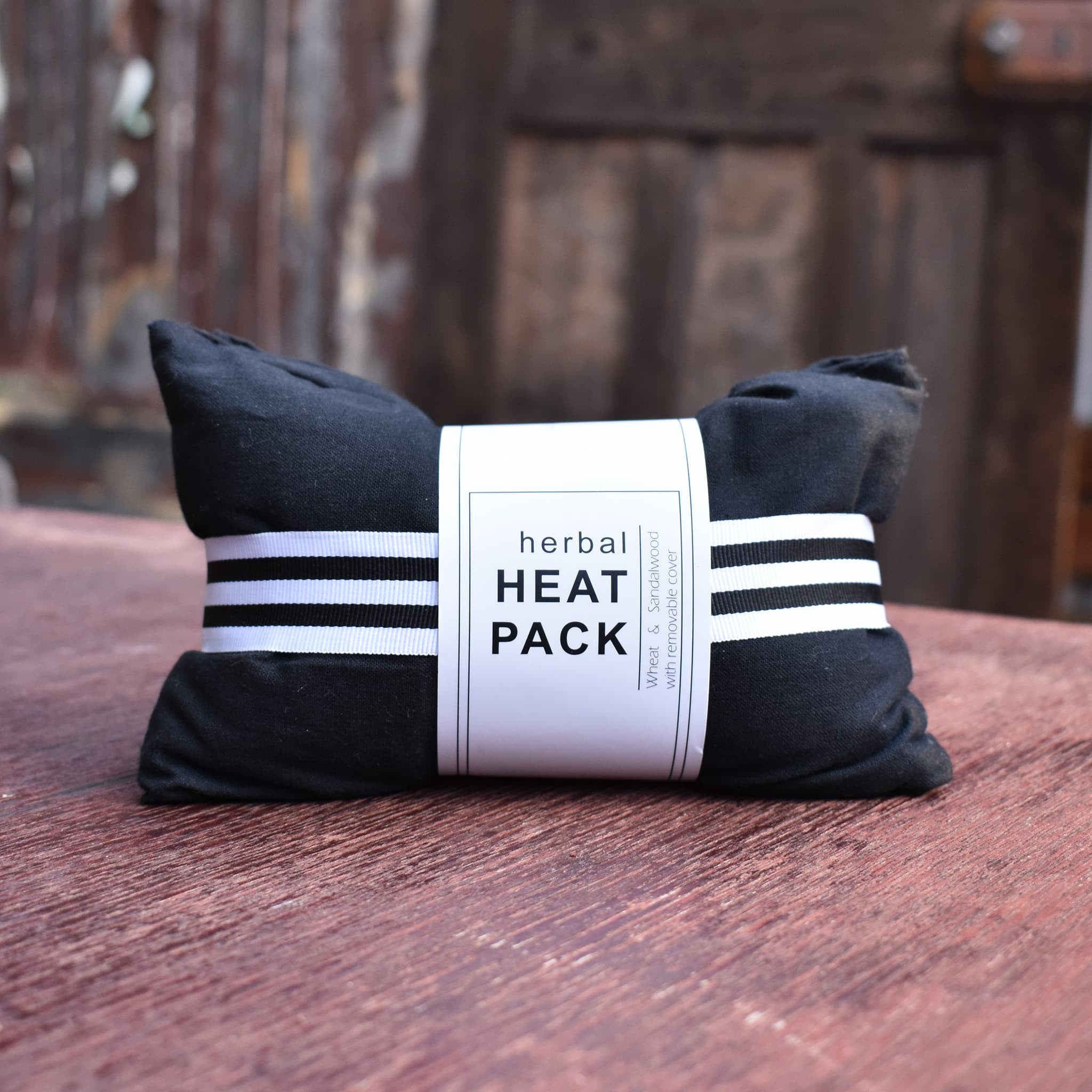 Heat pack, tailor made with black fabric cover. Contains wheat and sandalwood.