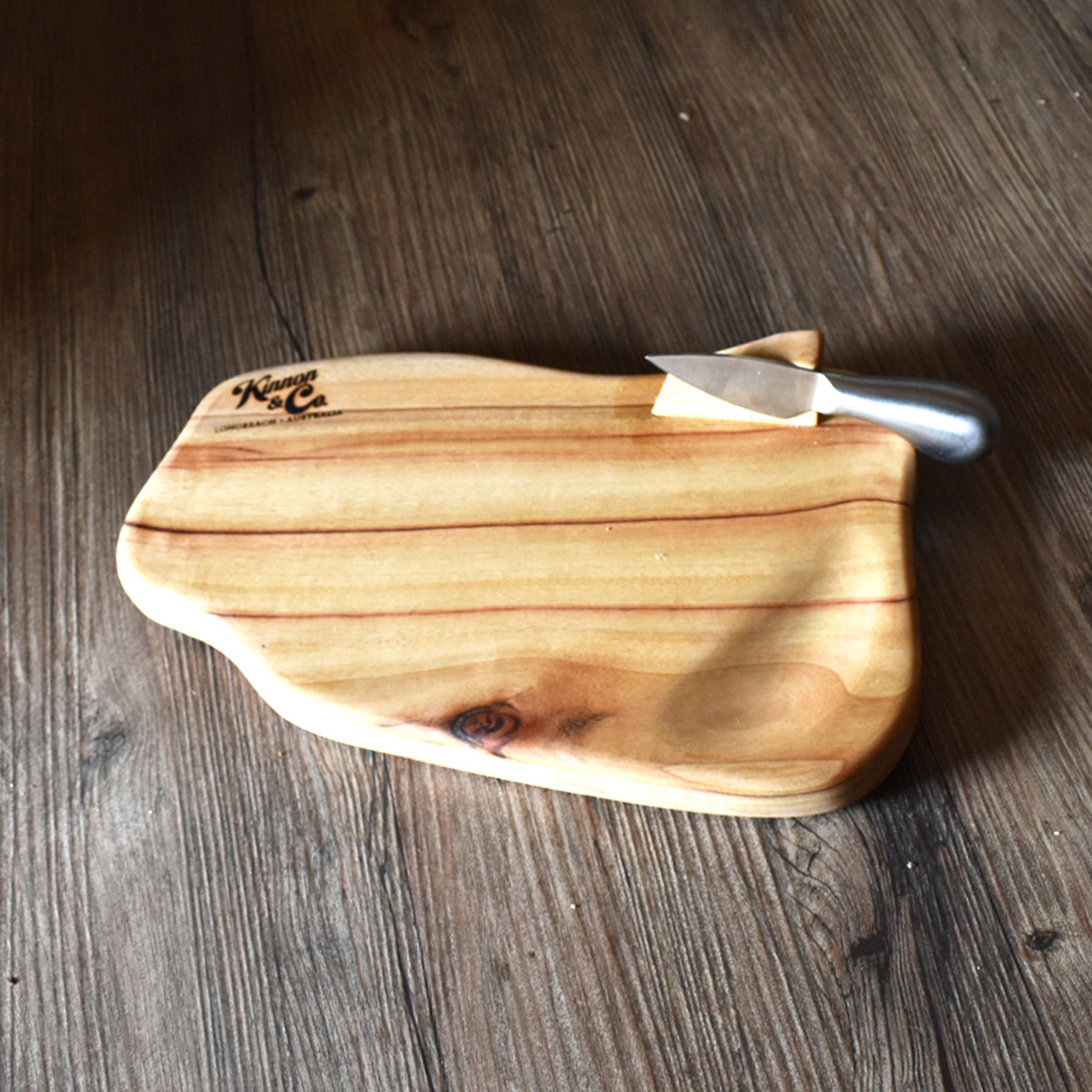 Chopping board with cheese knife attached and rustic timber background
