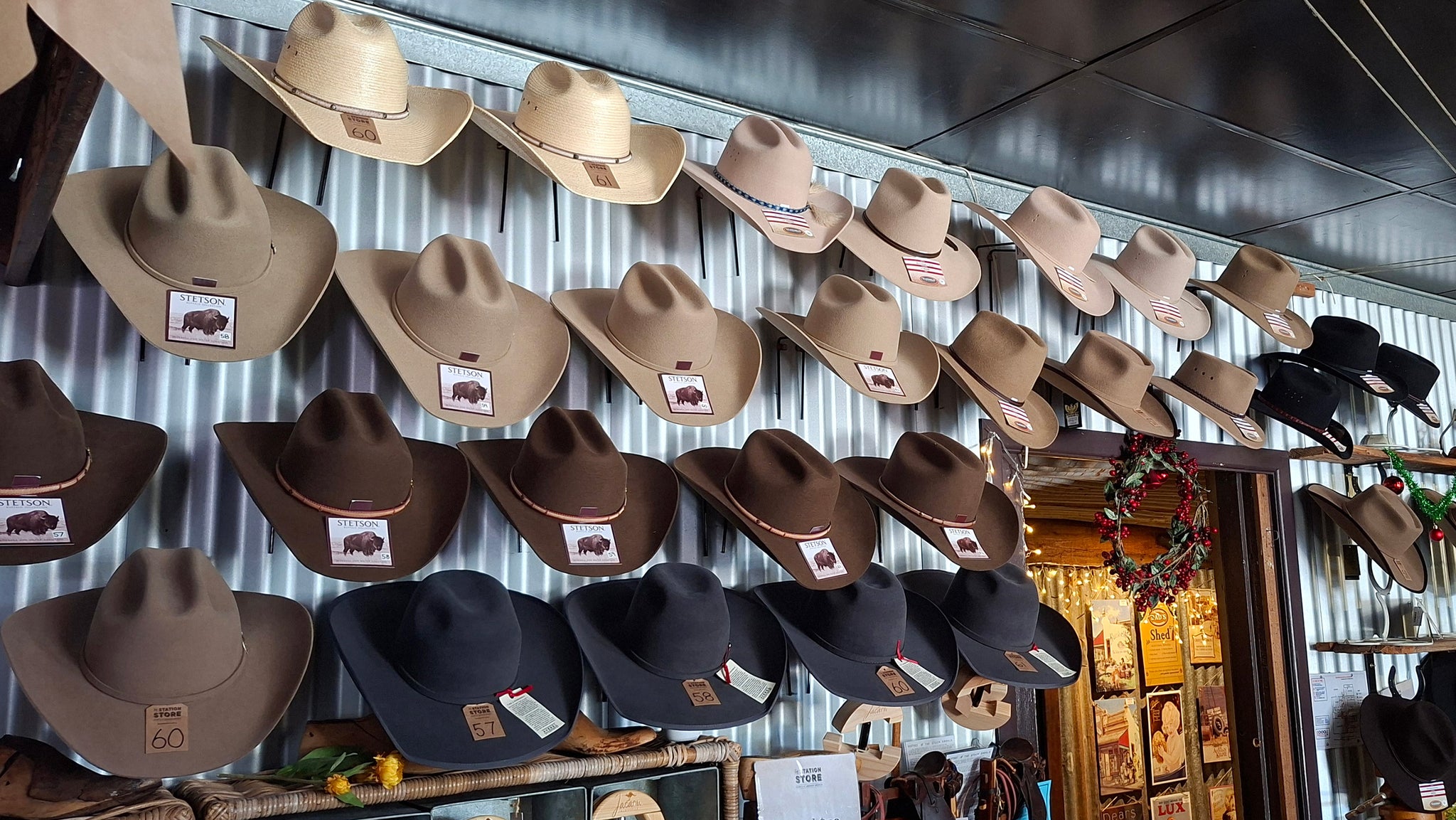 Display of outback cowboy hats on a wall with a rustic interior setting.