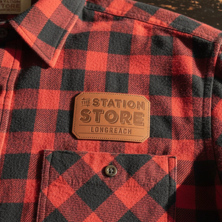 Leather iron on patch on red and black check shirt breast