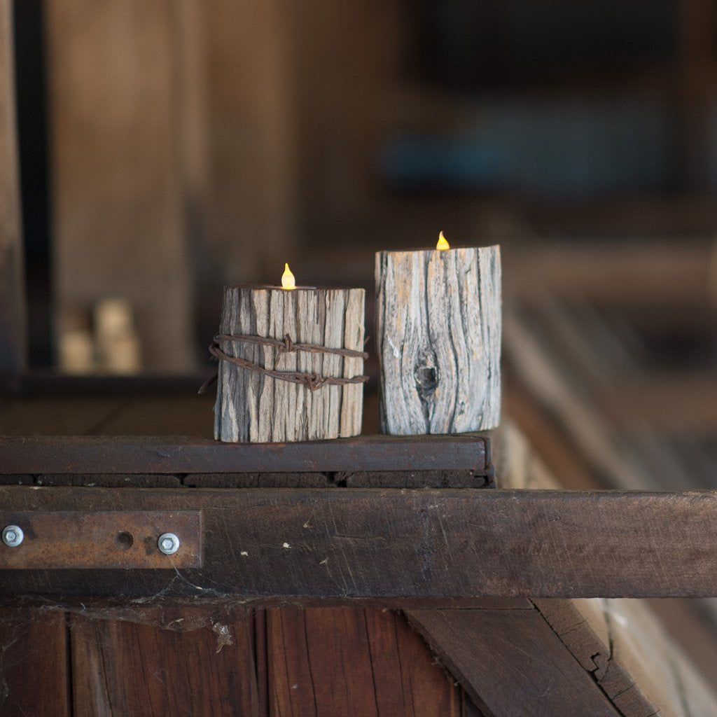Two Gidgee wood candle holders with candles. One with barb wire.