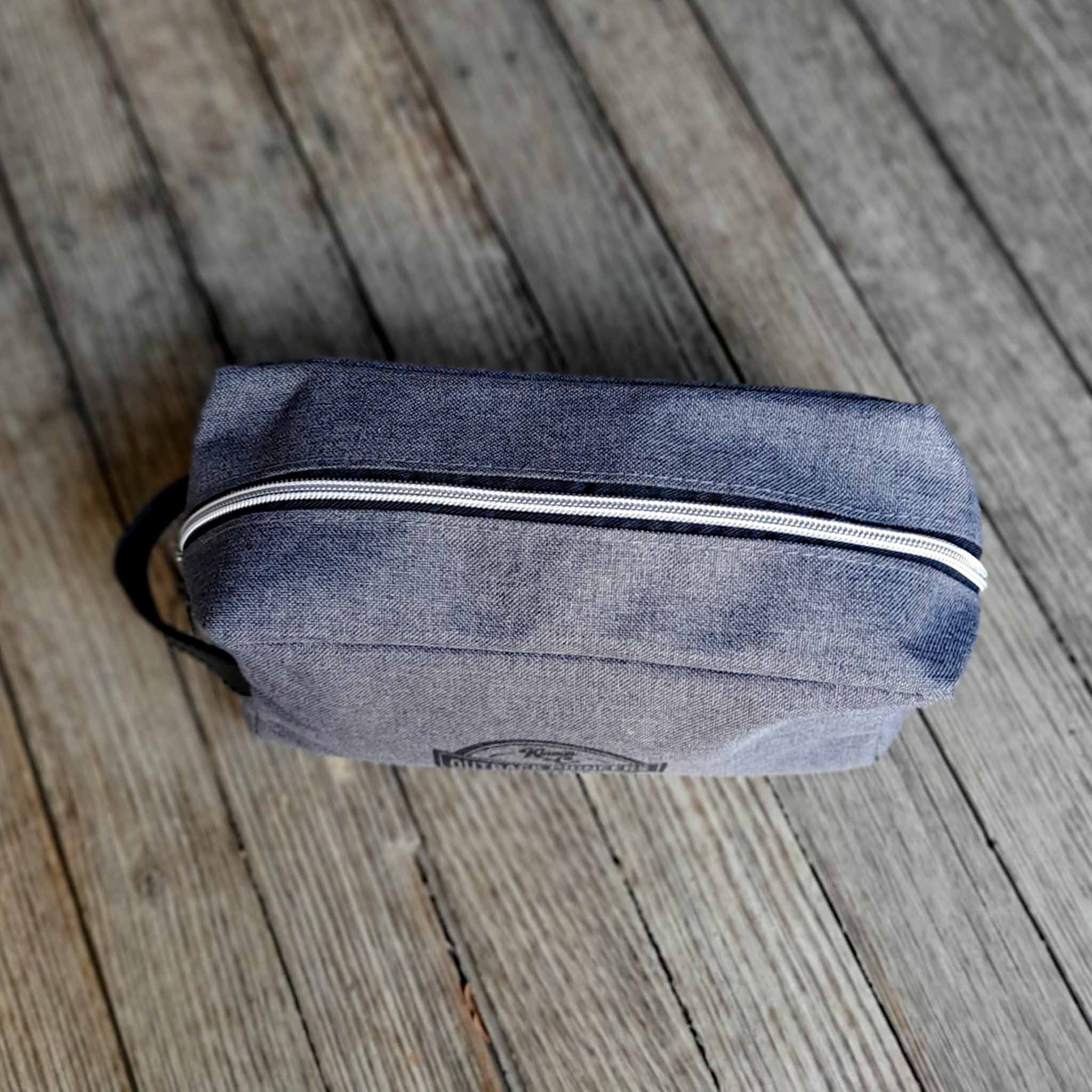 Outback Pioneers Toiletry Bag, grey heatherd finish and carry handle. Top view of chrome zipper. 